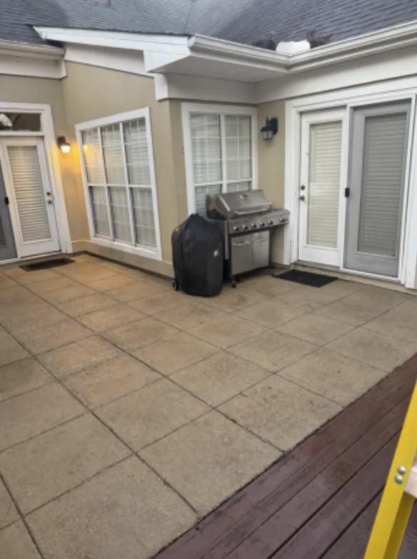 After: residential courtyard patio cleaning, dark buildup removed from the pavers