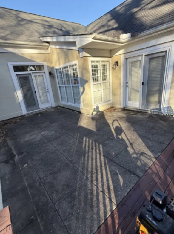 Before: residential courtyard patio cleaning, dark buildup removed from the pavers